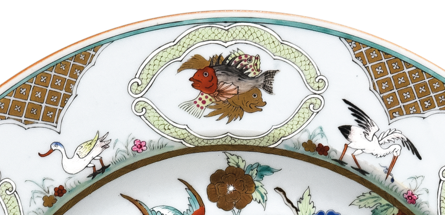 圖為清中期廣彩人物紋大碟細節(jié)圖，碟沿對稱開六窗繪魚紋，間繪六組鳥禽紋。（來源：廣州十三行博物館）